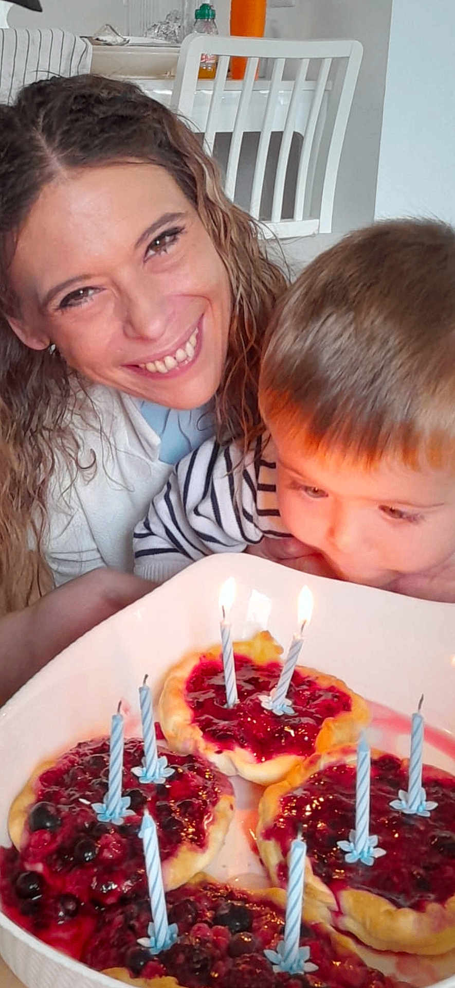 Samael participe au concours pour gagner de l'argent avec cette photo : woman, child, birthday, cake, candles, celebration, dessert, food, plate, happy, smiling, curly_hair, striped_shirt, indoor, table, closeup, family, home, light, face