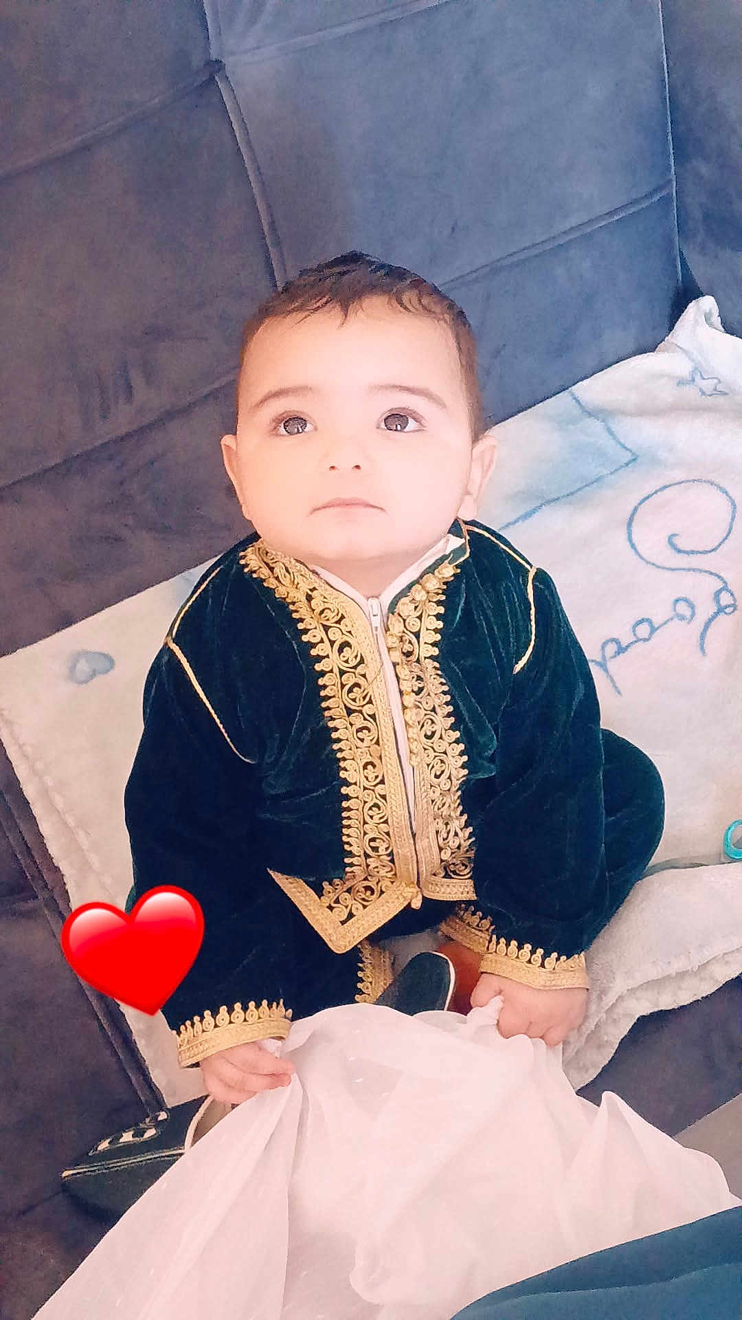Youcef Ilyane participe au concours pour gagner de l'argent avec cette photo : baby, child, velvet_clothing, gold_embroidery, couch, blanket, indoor, curious, sitting, face, hand, expression, heart_emoji, soft_lighting, portrait, young_child, cute, decor, fabric, home