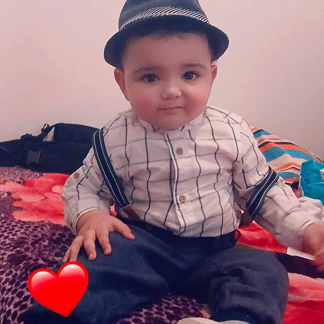 Youcef participe au concours pour gagner de l'argent avec cette photo : baby, bed, blanket, child, cute, face, fashion, hat, indoor, pants, pattern, person, portrait, red_heart_emoji, shirt, shoe, sitting, smile, sock, suspenders
