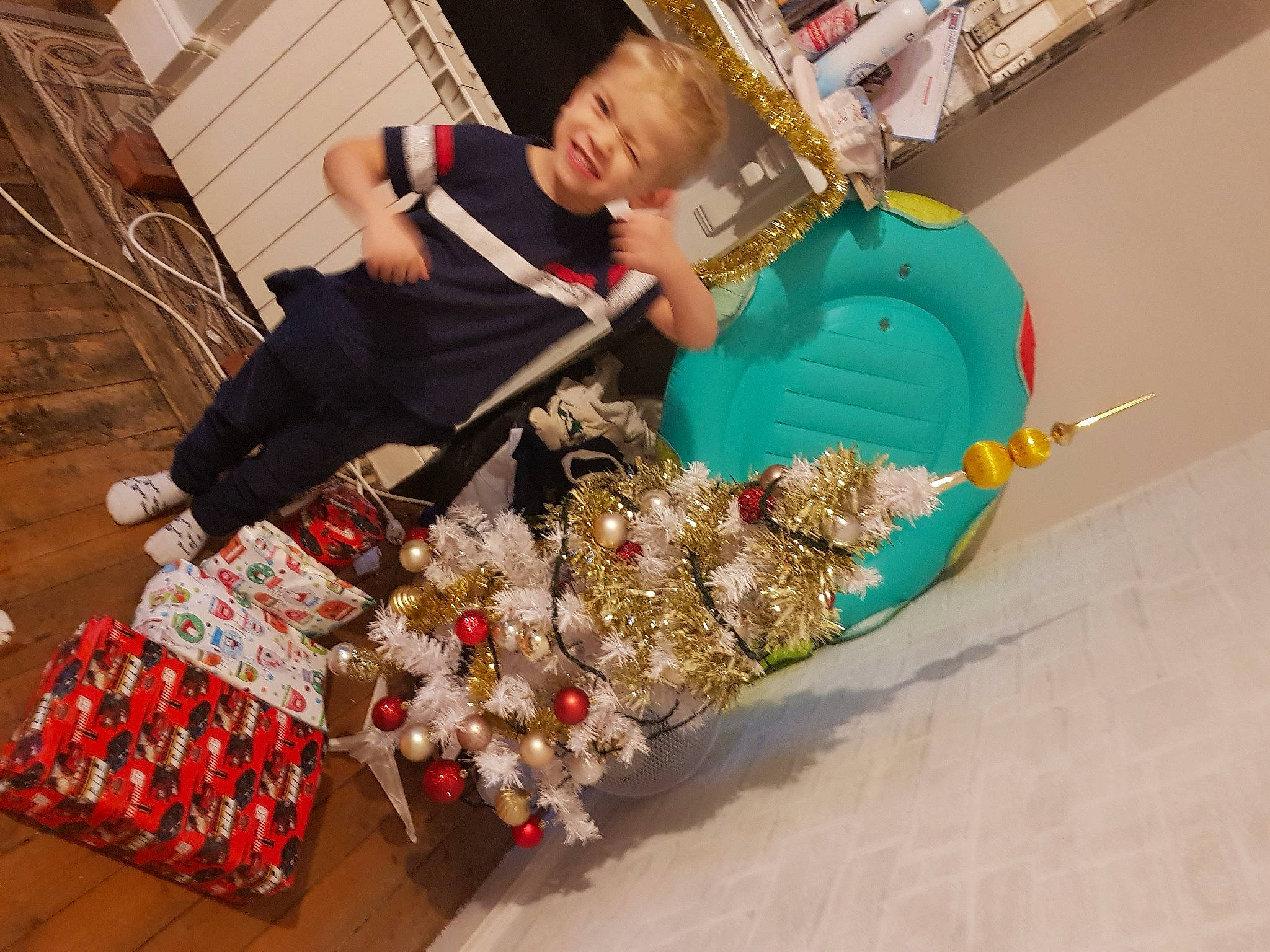 Kenny participe au concours pour gagner de l'argent avec cette photo : bag, christmas, christmas_tree, city, event, fashion_accessory, fun, happy, holiday, joy, leisure, marketplace, person, plastic, room, sitting, tradition, winter