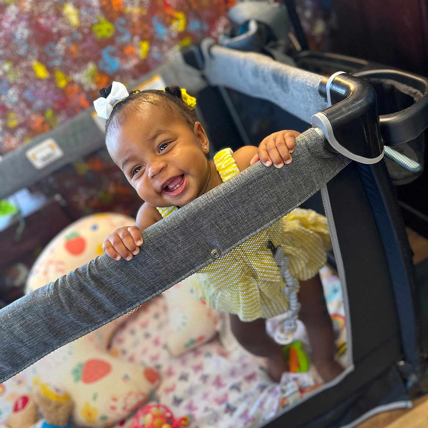 Kellontrea joined the competition — help win amazing prizes! baby, child, infant, smiling, happy, portrait, playpen, nursery, indoor, toys, colorful, blanket, dress, hair_bows, standing, hands, face, wood_floor, playmat, photography