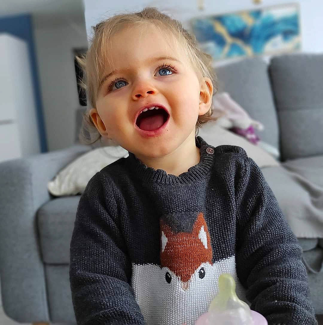 Clara a rejoint le concours — aidez-le/la à gagner de superbes lots ! baby, baby_toddler_clothing, cheek, eyebrow, eyelash, face, grey, happy, head, human_body, iris, lip, mouth, neck, nose, person, skin, sleeve, smile, toddler