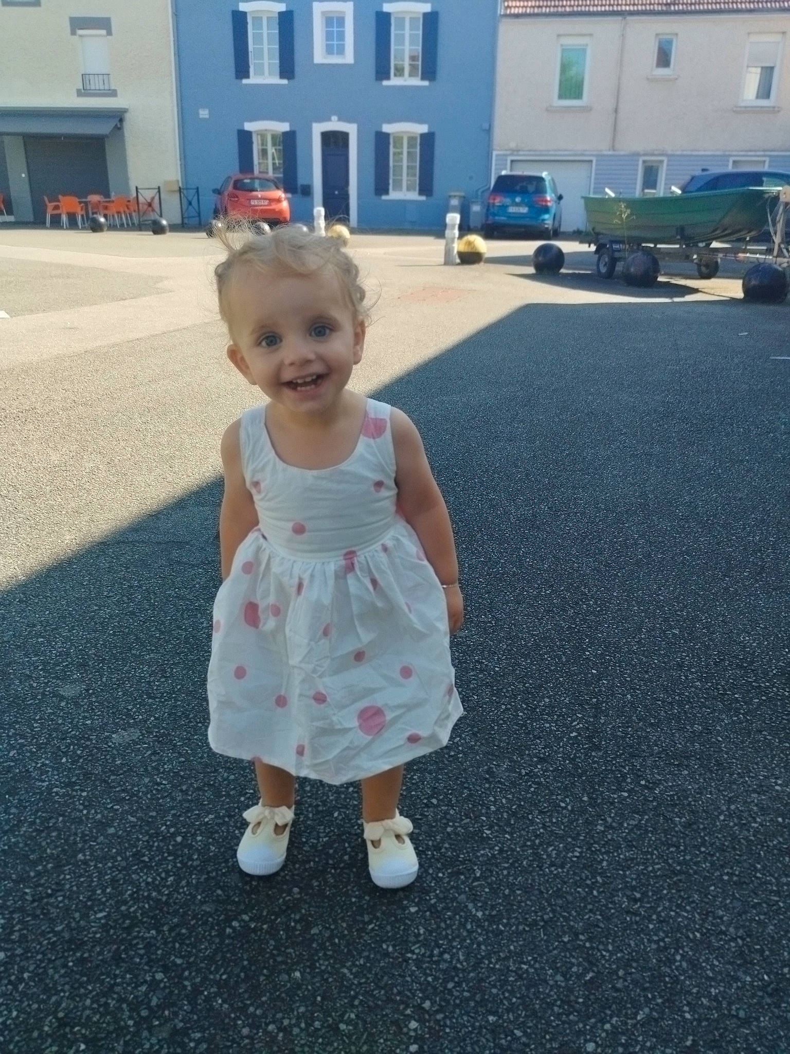 Malak a rejoint le concours — aidez-le/la à gagner de superbes lots ! asphalt, baby, baby_toddler_clothing, building, child, day_dress, dress, facial_expression, fun, grass, hand, happy, human_body, joy, person, road_surface, smile, standing, toddler, truck