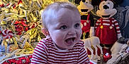 Arlen-Ray joined the competition — help win amazing prizes! baby, child, christmas_tree, holiday, plush_toys, mickey_mouse, minnie_mouse, striped_shirt, red_cushion, festive, decorations, indoors, joyful, crawling, smiling, toys, floor, winter, home, celebration