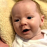 Luke is registered to the contest to win money with this photo: baby, blanket, child, close_up, clothing, cute, expression, eyes, fabric, face, hand, human, indoor, infant, mouth, newborn, portrait, skin, soft_texture, white_outfit