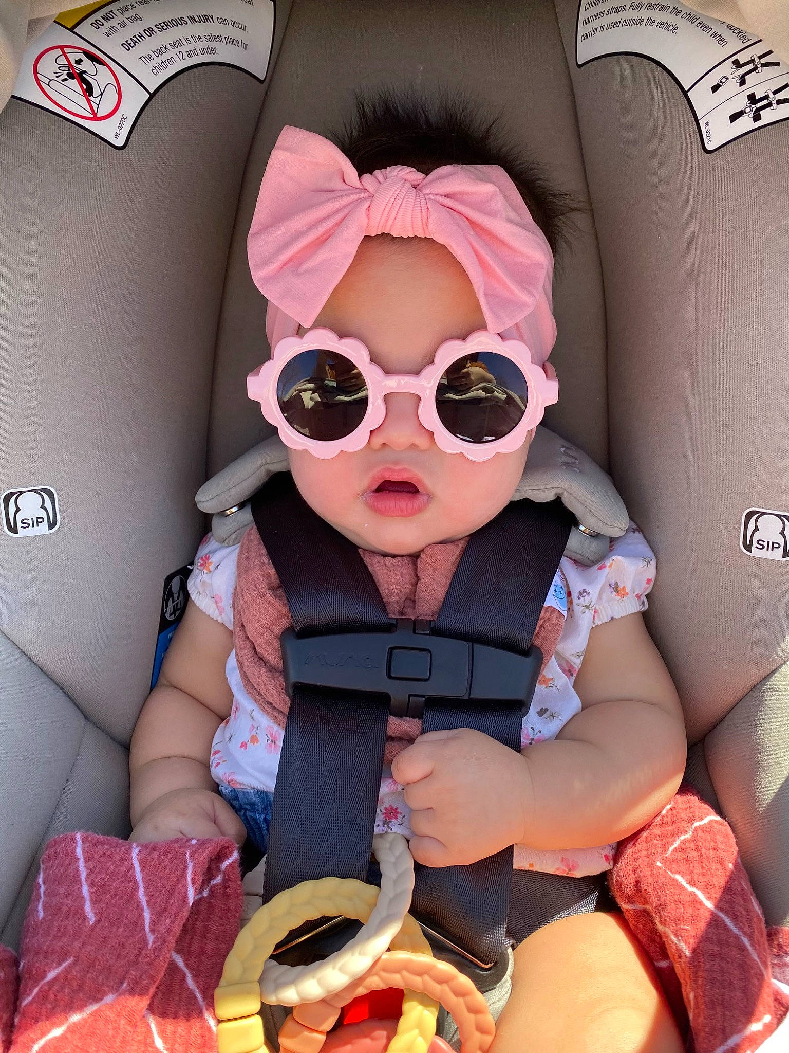 Kora is registered to the contest to win money with this photo: auto_part, baby_toddler_clothing, car_seat, car_seat_cover, carmine, comfort, eyewear, fashion_accessory, font, glasses, goggles, headwear, magenta, pattern, person, personal_protective_equipment, pink, product, sunglasses, tie