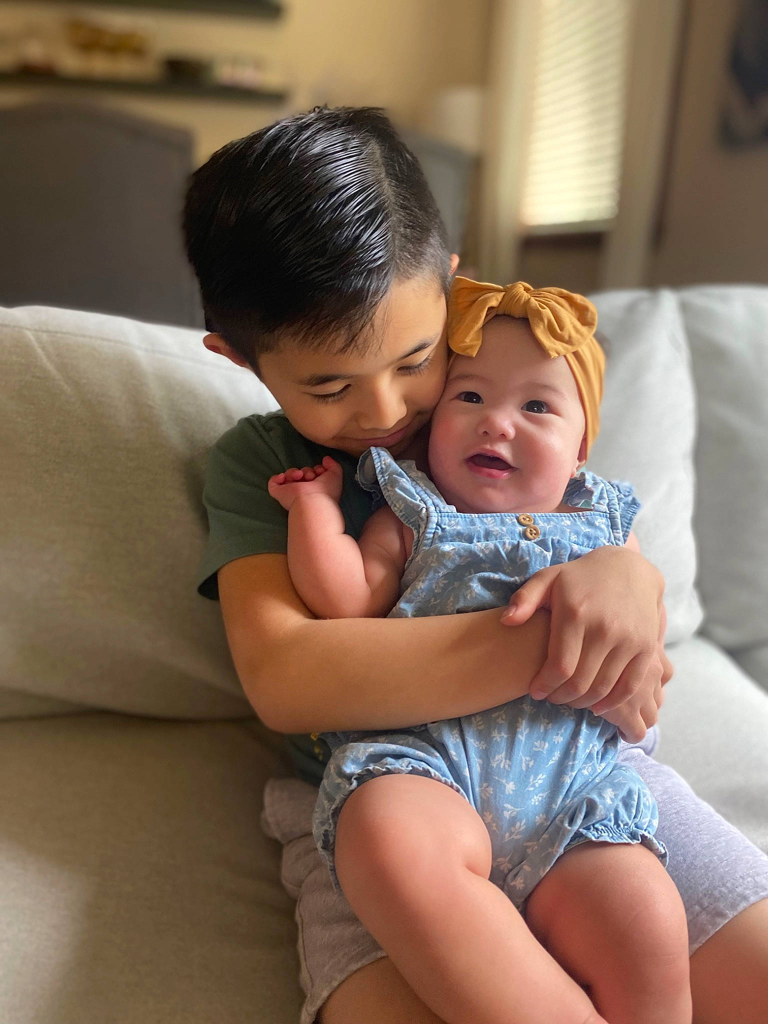 Kora joined the competition — help win amazing prizes! abdomen, arm, baby, child, comfort, couch, event, eye, face, fun, hair, happy, headwear, human_leg, leg, person, shorts, sitting, skin, smile