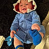 baby, child, blue_onesie, shark_hood, smiling, happy, socks, floor, rug, indoor, playful, cute, infant, clothing, footwear, person, portrait, candid, cozy, home