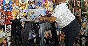 Kyaire is registered to the contest to win money with this photo: toddler, child, black_stool, collage, family_photos, baby, wall, footwear, white_shirt, black_shorts, curly_hair, indoor, smiling_faces, photography, floor, standing, colorful, people, portrait, casual_clothing
