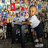 Kyaire joined the competition — help win amazing prizes! toddler, child, sneakers, stool, collage, photographs, indoor, portrait, curious, black_stool, wall_art, family, person, floor, clothing, happy, expression, shoes, shorts, white_shirt