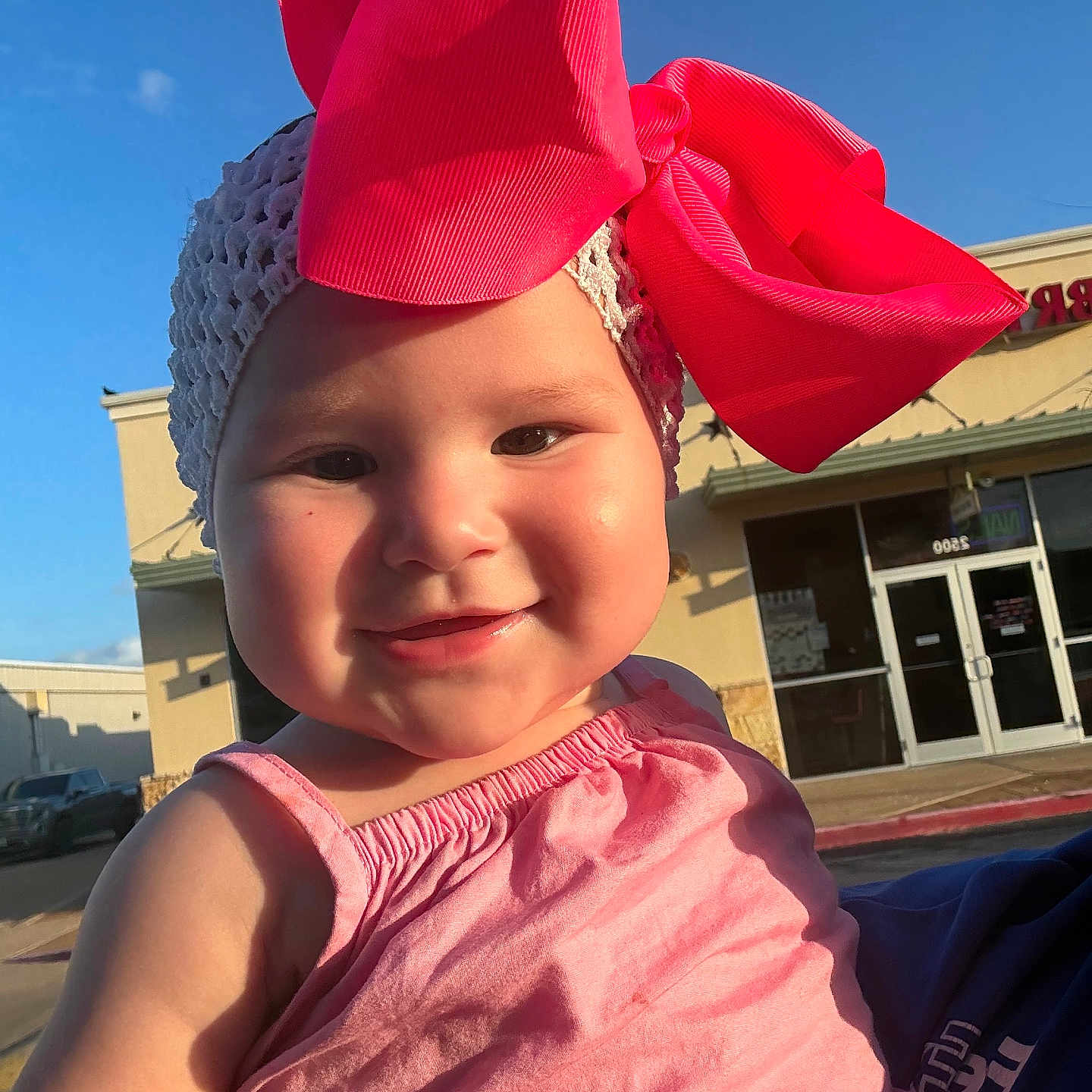 Annaaleyah joined the competition — help win amazing prizes! baby, child, girl, pink_bow, headband, dress, smile, outdoor, sunlight, cheeks, face, happy, person, retail_building, shopping_plaza, window, door, daylight, clothing, cute