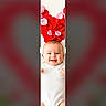 baby, infant, smiling, flower_petals, white_clothing, lying_down, portrait, cute, child, happy, skin, head, hands, feet, red, pink, background_blur, mobile_screen, crop_selection, digital