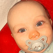 Warrenn a rejoint le concours — aidez-le/la à gagner de superbes lots ! baby, bald_head, blanket, blue_eyes, cheek, closeup, cute, eyelashes, eyes, face, hooded_clothing, infant, lying_down, nose, pacifier, portrait, red_background, skin, smile, soft_texture