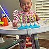 baby, child, toddler, smiling, indoors, activity_walker, toy, pink_pajamas, hello_kitty, infant, standing, playtime, nursery, window, blinds, household, furniture, colorful, portrait, happy