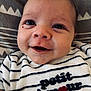 baby, blanket, child, closeup, clothing, cute, eyes, face, happy, head, infant, lying_down, pattern, person, portrait, skin, smiling, striped_shirt, text_embroidery, young
