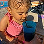 Victoire a rejoint le concours — aidez-le/la à gagner de superbes lots ! toddler, child, swimsuit, pink, wet_hair, drinking, blue_cup, straw, summer, pool, outdoor, sunlight, table, hand, person, closeup, refreshment, water, casual, daytime