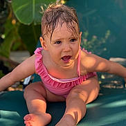 Victoire participe au concours pour gagner de l'argent avec cette photo : toddler, child, swimsuit, pink, wet_hair, outdoor, lounge_chair, green, leaf, summer, sunlight, expression, barefoot, skin, person, nature, cute, sitting, daylight, playful