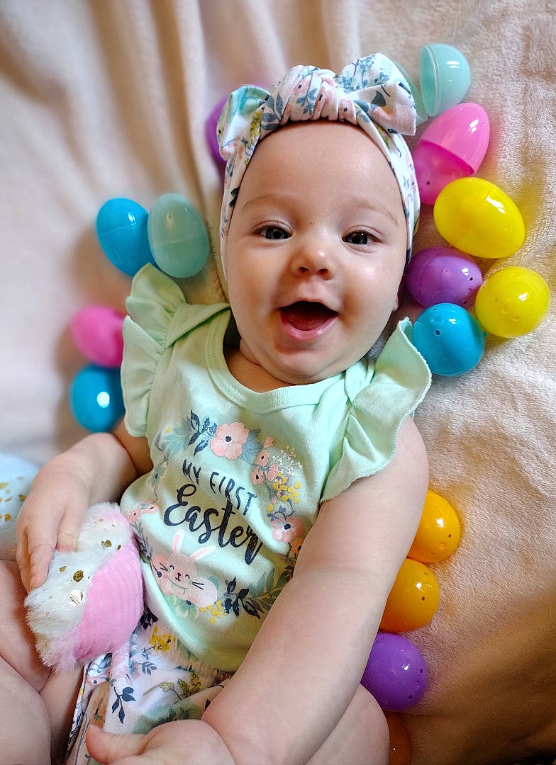 Emerald is registered to the contest to win money with this photo: aqua, arm, baby, baby_toddler_clothing, balloon, child, face, facial_expression, finger, fun, gesture, happy, head, headwear, people, person, pink, product, skin, smile