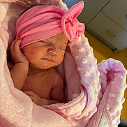 Chloé a rejoint le concours — aidez-le/la à gagner de superbes lots ! baby, newborn, sleeping, pink_blanket, pink_headband, bow, infant, wrapped, cozy, soft_texture, peaceful, closeup, indoor, child, cute, portrait, skin, hand, resting, blanket