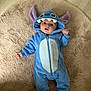 baby, onesie, blue_clothing, costume, cute, child, infant, floor, rug, plush, ears, face, portrait, socks, expression, indoor, sleepwear, soft_texture, lying_down, curious
