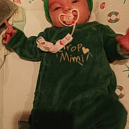 Inès a rejoint le concours — aidez-le/la à gagner de superbes lots ! baby, infant, pacifier, green_clothing, headband, onesie, lying_down, bed, mattress, pattern, soft_lighting, cute, child, indoor, sleepwear, face, person, toddler, comfort, young_child