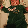 baby, infant, pacifier, green_clothing, headband, onesie, lying_down, bed, mattress, pattern, soft_lighting, cute, child, indoor, sleepwear, face, person, toddler, comfort, young_child