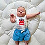 baby, infant, cute, smiling, blue_shorts, striped_tank_top, red_crab, cushion, white_fluffy, lying_down, indoors, child, portrait, happy, skin, face, arm, legs, footwear_free, soft