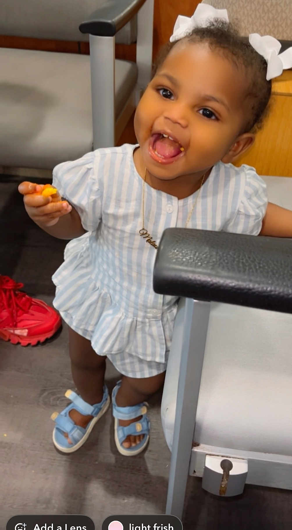 Malaun joined the competition — help win amazing prizes! toddler, child, smiling, happy, indoor, dress, sandals, hair_bows, snack, chair, floor, red_shoes, person, footwear, wooden_floor, furniture, cute, playful, portrait, young_child