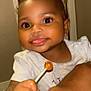 Malaun is registered to the contest to win money with this photo: baby, child, lollipop, smile, face, hand, indoor, person, cute, happy, food, sweet, young_child, skin, arm, light, expression, holding, tongue, clothing