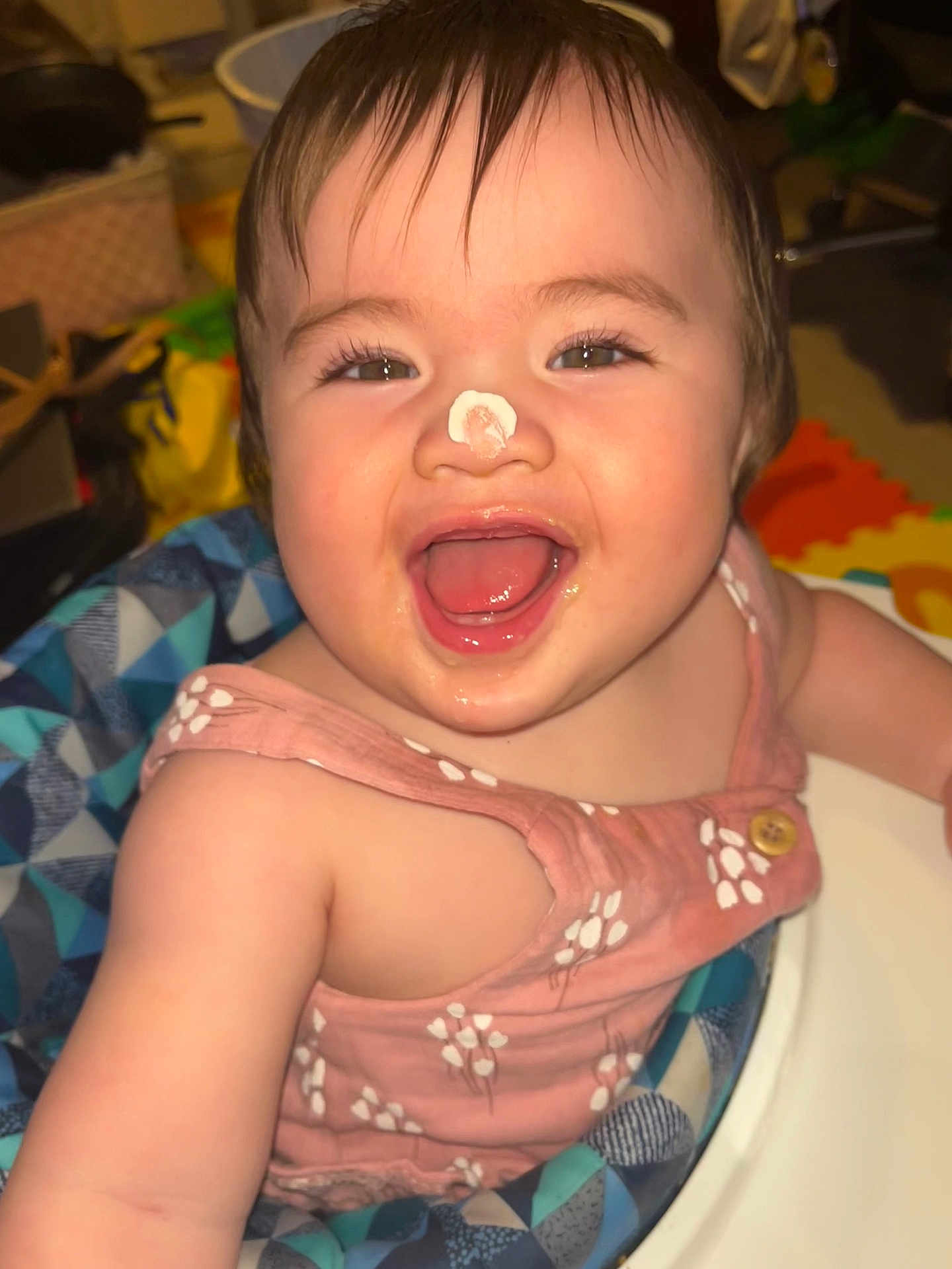 Nicholette is registered to the contest to win money with this photo: baby, child, face, smile, happy, cream, nose, pink_clothing, high_chair, infant, cute, joyful, indoor, person, young_child, expression, sitting, fun, playful, closeup