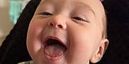 Noah is registered to the contest to win money with this photo: baby, smiling, laughing, striped_clothing, infant, face, happy, person, indoors, closeup, cute, young_child, head, skin, mouth_open, teeth, eyes, comfort, home, television