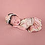 newborn, baby, sleeping, pink_background, headband, flower, lace, dress, infant, soft_texture, peaceful, cute, portrait, resting, child, indoors, tiny_hands, delicate, adorable, sleep