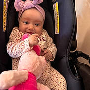 Chloe joined the competition — help win amazing prizes! baby, infant, child, car_seat, pink_headband, bow, floral_pajamas, stuffed_animal, toy, smiling, happy, cute, indoors, seatbelt, child_safety, portrait, closeup, person, young, comfort