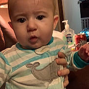 Lucas is registered to the contest to win money with this photo: baby, beverage, blade, bodypart, bottle, couch, face, finger, frown, furniture, hand, head, mineralwater, person, photography, portrait, razor, sad, waterbottle, weapon