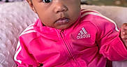 Malyiah joined the competition — help win amazing prizes! adidas, adorable, baby, child, closeup, clothing, cozy, cute, expression, face, fashion, hair_bows, indoors, person, pink_tracksuit, portrait, seated, sitting, toddler, young_child