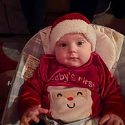James joined the competition — help win amazing prizes! baby, baby_seat, child, christmas, christmas_theme, cozy, cute, cute_expression, festive, holiday, holiday_outfit, holiday_season, indoors, infant, plush, portrait, red_clothing, santa_hat, smiling_face, young_child