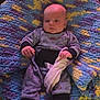 James joined the competition — help win amazing prizes! baby, infant, onesie, blanket, knit_blanket, soft_toy, clothing, person, indoor, cute, child, newborn, hand, face, head, sitting, comfort, pattern, colorful, cozy