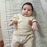 Mathius a rejoint le concours — aidez-le/la à gagner de superbes lots ! baby, beige_clothing, bracelet, child, comfortable, cute, expression, hands, head, indoors, infant, laying_down, legs, person, portrait, quilted_bedspread, skin, soft_lighting, teddy_bear_patch, young_child
