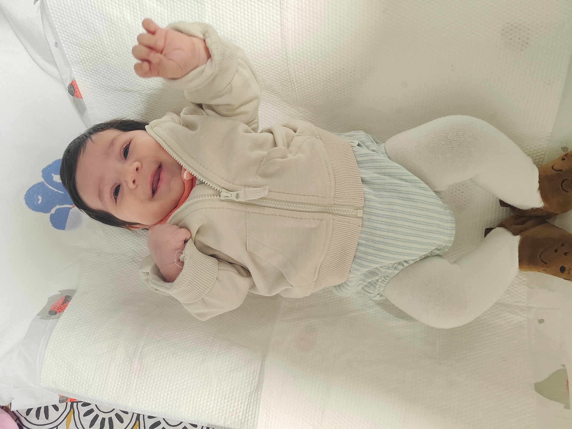 Mathius a rejoint le concours — aidez-le/la à gagner de superbes lots ! baby, booties, child, clothing, cozy, cute, face, hand_raised, happy, indoor, infant, jacket, lying_down, person, playful, sleeping_area, smiling, soft_surface, striped_shorts, white_tights