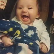 Armani is registered to the contest to win money with this photo: baby, blanket, unicorn, car_seat, smiling, child, happy, infant, cute, cozy, clothing, person, indoor, closeup, face, hand, soft, warm, joyful, expression