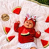 baby, infant, watermelon, red_clothing, headband, bow, blanket, grass, diaper, fruit, summer, outdoor, cute, lying_down, wooden_sign, four_months, fresh, healthy, playful, child