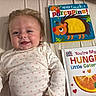 Everly joined the competition — help win amazing prizes! baby, bed, book_cover, books, caterpillar, child, clothing, colorful, cute, happy, indoor, infant, long_sleeve, lying_down, person, playful, porcupine, reading, smiling, soft_lighting