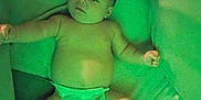 Matthew is registered to the contest to win money with this photo: baby, diaper, infant, lying_down, arm_outstretched, enclosed_space, green_tint, soft_lighting, baby_items, cozy, child, person, cute, indoor, blanket, toy, face, head, skin, newborn