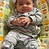 baby, infant, child, smiling, portrait, sitting, bouncer, baby_seat, purple_bow, gray_outfit, cartoon_clothing, hands, indoors, cozy, colorful, winnie_the_pooh, cushion, close_up, happy, photography