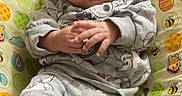 Heaven is registered to the contest to win money with this photo: baby, infant, child, smiling, portrait, sitting, bouncer, baby_seat, purple_bow, bow_headband, pajamas, cartoon_clothing, winnie_the_pooh, colorful, indoors, cozy, hands, dark_hair, close_up, happy