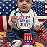 Navisha joined the competition — help win amazing prizes! baby, child, patriotic, 4th_of_july, flag, red_white_blue, headband, bib, toy, celebration, confetti, sitting, indoor, face, smile, hat, clothing, floor, decor, holiday