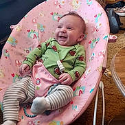 Beau Wesley Graham joined the competition — help win amazing prizes! baby, infant, smiling, baby_chair, pink, green_onesie, striped_leggings, toy, living_room, carpet, furniture, happy, child, cute, indoor, person, seat, footwear, wooden_cabinet, cozy