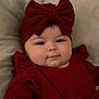 Ariane participe au concours pour gagner de l'argent avec cette photo : baby, infant, red_clothing, headband, bow, face, smile, lying_down, soft_surface, cute, child, portrait, indoors, young_child, warm_colors, adorable, chubby_cheeks, headwear, human, happy