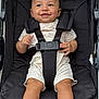 baby, smiling, stroller, child, seatbelt, happy, infant, clothing, footwear, socks, person, portrait, babywear, cute, young, sitting, outdoor, black, comfort, seat