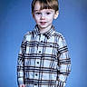 child, boy, plaid_shirt, portrait, smile, standing, indoor, blue_background, casual_clothing, young, cute, person, fashion, hair, eyes, face, childhood, happy, model, studio